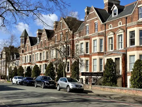 Exterior view of The Arundel House Hotel with elegant Victorian architecture and welcoming entrance taken from across the street.